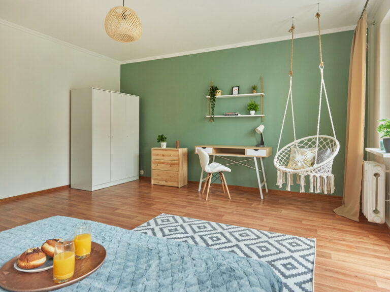 Sypialnia z łóżkiem, szafą i biurkiem z widokiem za okno w mieszkaniu przy ul. Osmeckiego 15 w Rzeszowie. Niezłe Lokum kompleksowo urządziło to wnętrze.